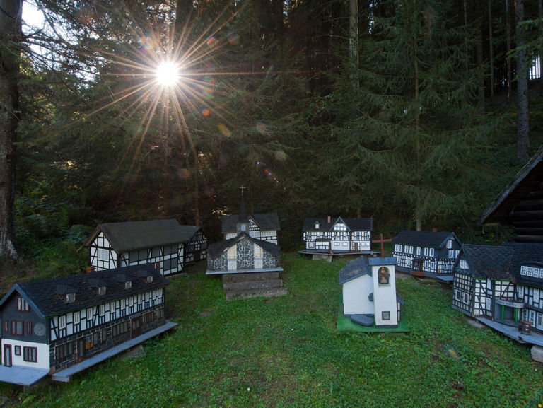Der Hammerkotten: kleine, nachgebaute Wenholthauser Häuser im Wald 