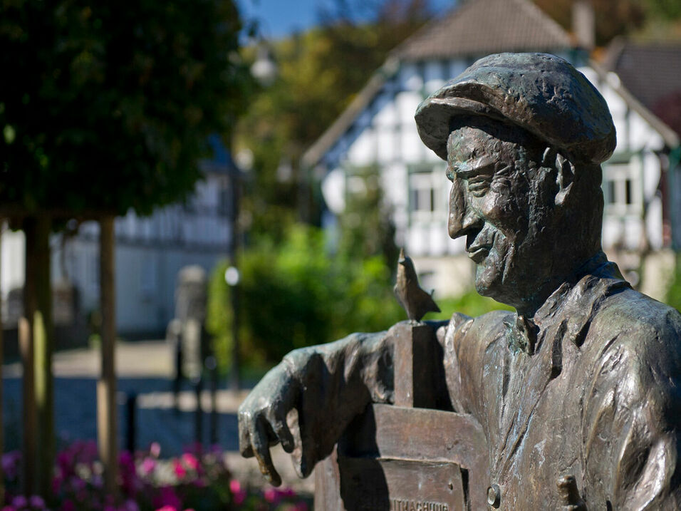 Bronzefigur des Esloher Originals "Pampel" am Spritzenhaus in Eslohe, Sauerland